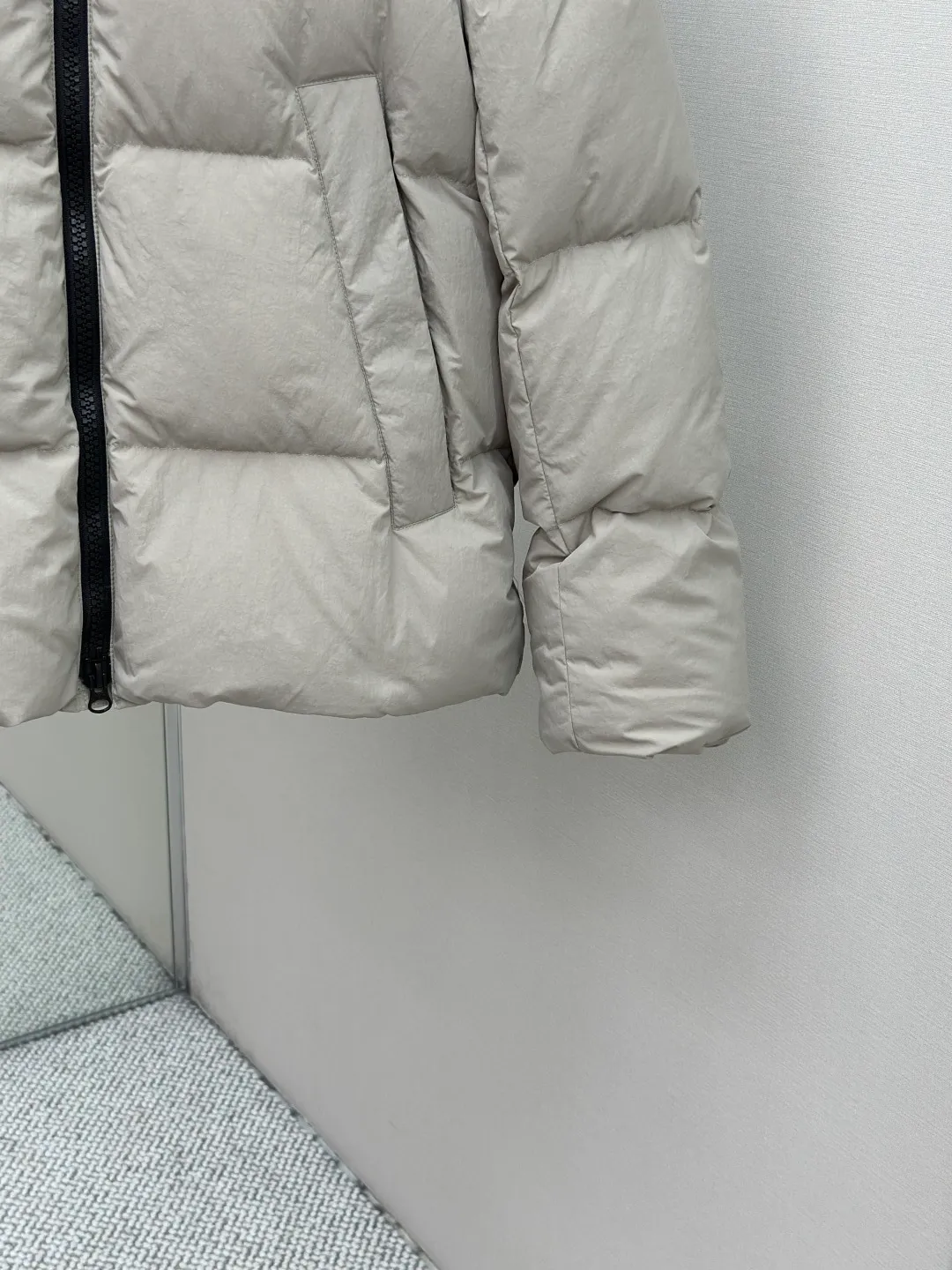 P1010 Canada Goose Black Label Badge Hooded Down Jacket (khaki) The high-quality filling is made of 90 national standard high-quality white duck down, selected high-loft velvet, weighing 240g, light and warm, with excellent temperature locking performance and good resilience. The fabric is woven with 400T high-count yarn. After special water-repellent treatment, the surface forms a lotus leaf effect - raindrops will slide down like beads, and snow particles will fall off when touched. The tear resistance reaches 200N (approximately 20kg load-bearing), the light gray matte texture breaks the stereotype of "outdoor clothing = hardcore", and the soft luster presents a high-end matte effect under urban neon lights, seamlessly switching scenes from ski resorts to CBD office buildings. The ribbon is woven with polyester as the base, and the brand letters are decorated on the ribbon through high-precision computer embroidery. The edges of the pattern are clear, the stitches are fine and even, and multiple layers of embroidery thread are stacked to enhance the three-dimensional effect. Precision thread reinforcement prevents linting and ensures the fluffy and resilient elasticity lasts as new. The embedded cuffs are three-dimensionally woven to form a "wavy" elastic structure, which forms natural folds when fitting the wrist, increasing the contact area with the skin, thus improving the windproof effect. At the same time, micro-velvet treatment is added to the inside of the cuffs, which feels like a second layer of skin and avoids friction on the skin from metal zippers or hard fabrics. Size:S-M-L-XL